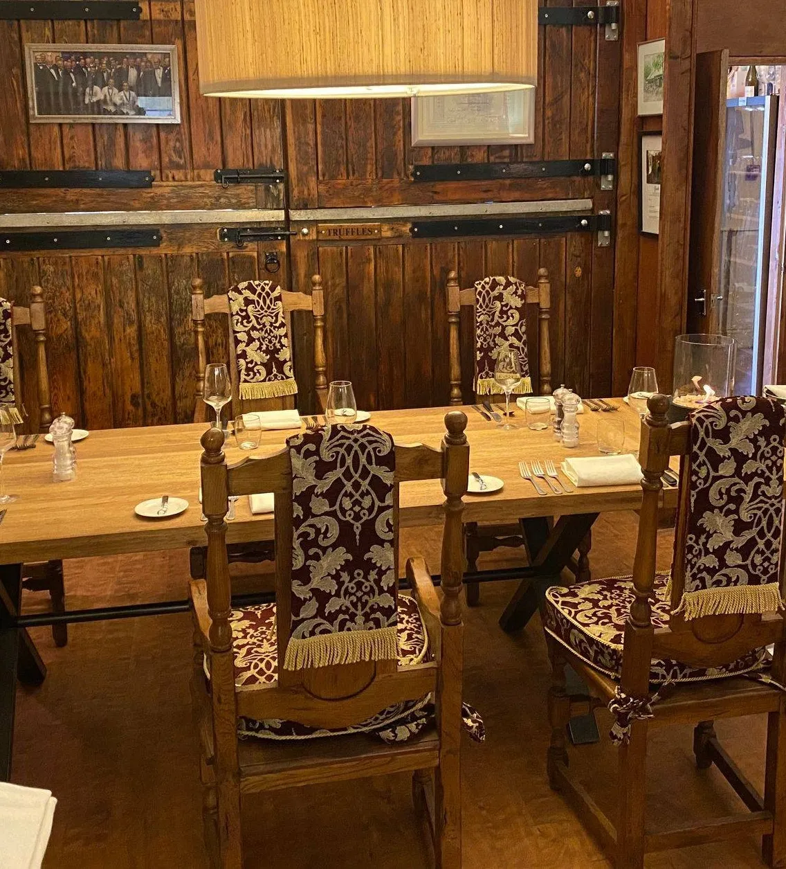 A chef's table at Chez Moi, laid for dinner against the wooden panelling